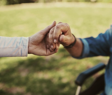 Caretaker holding person's hand