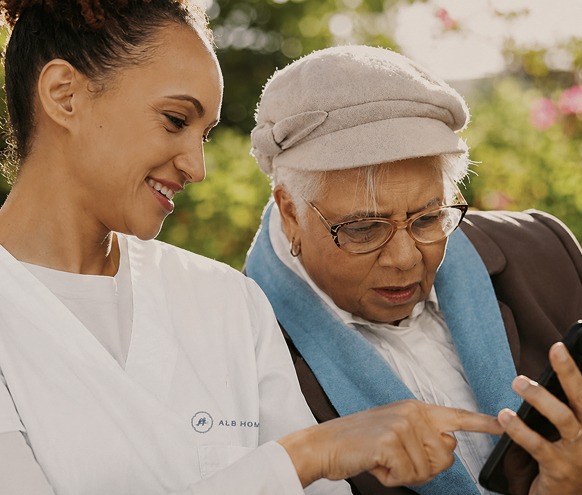 Caretaker helping person with her mobile phone