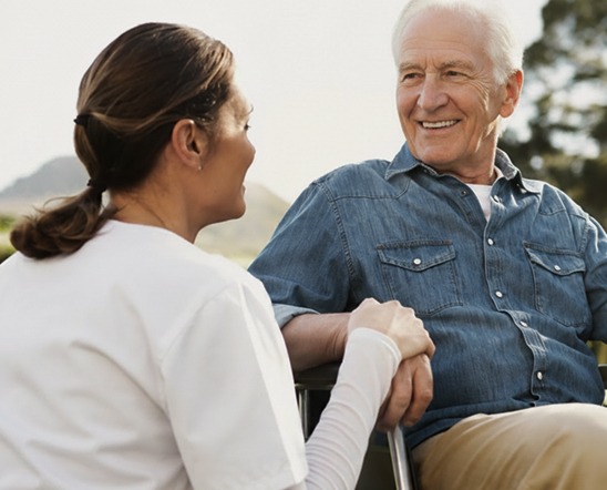 Caretaker comforting person in wheelchair