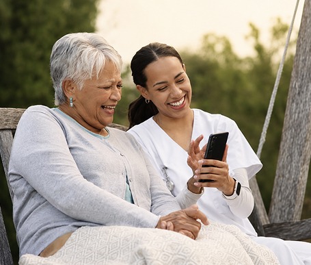 Caretaker helping person with mobile phone